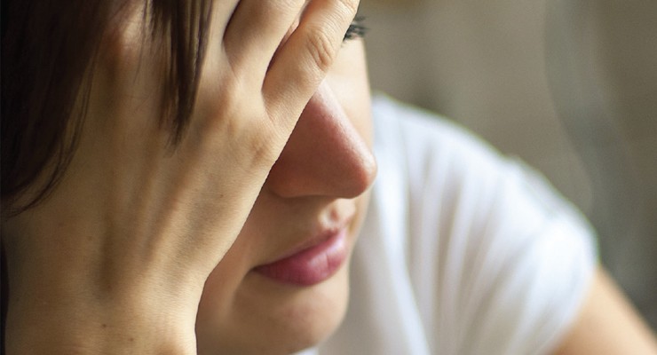 woman holding her head in her hand.