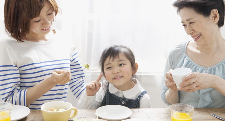 mother, daughter and granddaughter sitting at breakfast