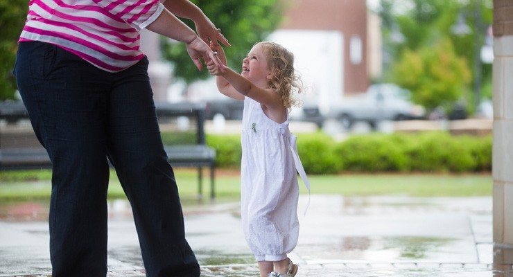 woman and small child dancing on patio